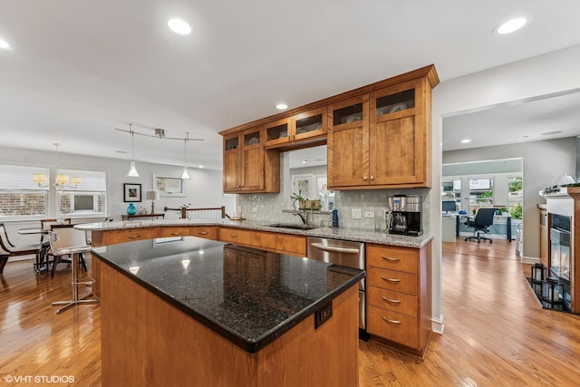 1820 N 75th Ct, Elmwood Park, IL 60707 - kitchen featuring brown cabinetry, a peninsula, light wood-style flooring, tasteful backsplash, and recessed lighting