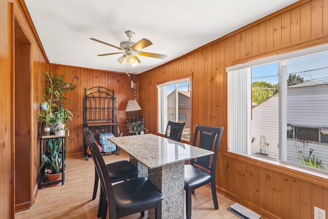 4517 N Austin Ave, Chicago, IL 60630 - dining space with wooden walls, a ceiling fan, light wood-type flooring, and crown molding