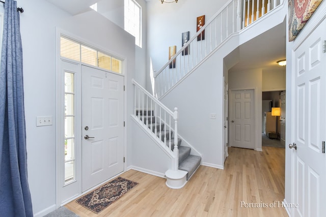 239 Morgan Valley Dr, Oswego, IL 60543 - entrance foyer featuring wood finished floors, a high ceiling, and stairway