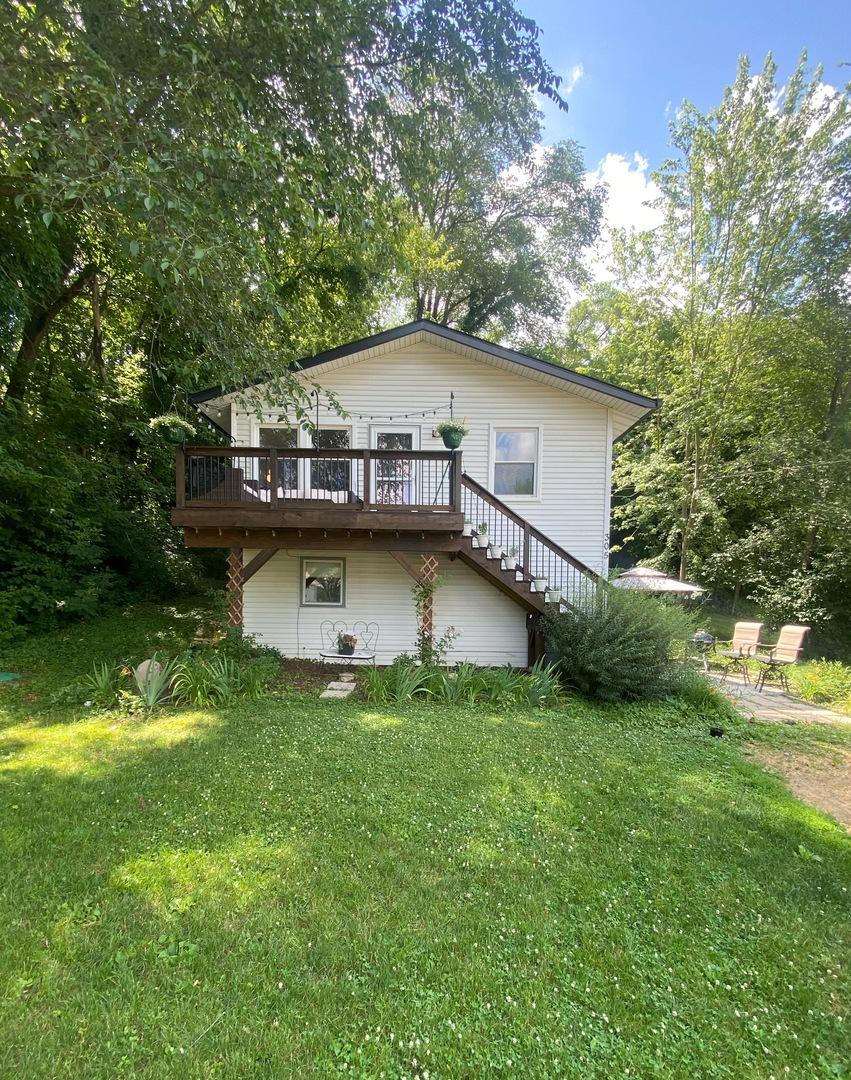 305 N Blackhawk Dr, Byron, IL 61010 - back of house featuring stairs, a wooden deck, a lawn, and a patio