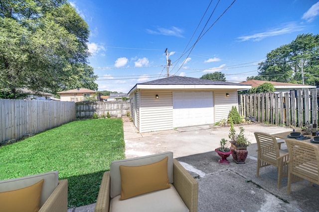 14112 S Hoxie Ave, Burnham, IL 60633 - fenced backyard with a garage, concrete driveway, an outbuilding, and a patio