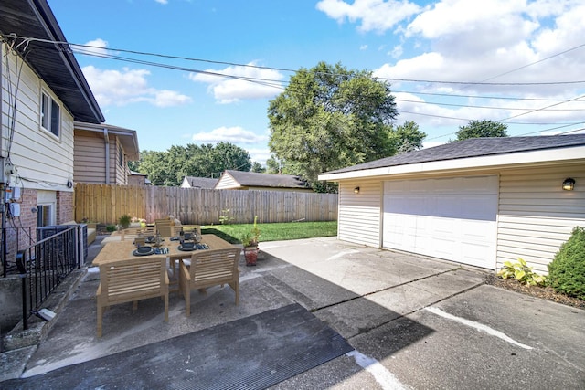 14112 S Hoxie Ave, Burnham, IL 60633 - view of patio / terrace featuring an outbuilding, concrete driveway, outdoor dining space, and a garage