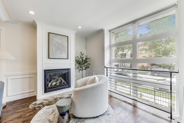 2423 W Erie St, Chicago, IL 60612 - sitting room featuring a decorative wall, ornamental molding, a large fireplace, wood finished floors, and a wainscoted wall