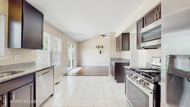 228 Dunton Ct, Mundelein, IL 60060 - kitchen with stainless steel appliances, a ceiling fan, vaulted ceiling, dark brown cabinetry, and light tile patterned floors