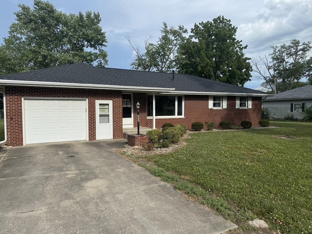 208 N Wisconsin St, Atwood, IL 61913 - single story home featuring an attached garage, brick siding, and concrete driveway