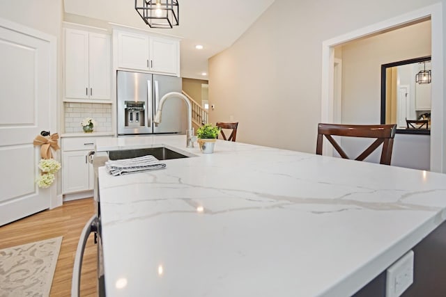 1723 Glenbridge Rd, Bloomington, IL 61704 - kitchen with stainless steel refrigerator with ice dispenser, light wood-style floors, white cabinetry, tasteful backsplash, and recessed lighting