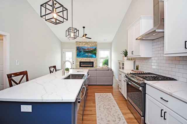 1723 Glenbridge Rd, Bloomington, IL 61704 - kitchen with appliances with stainless steel finishes, wall chimney exhaust hood, a fireplace, an island with sink, and open floor plan
