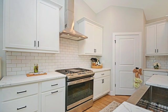 1723 Glenbridge Rd, Bloomington, IL 61704 - kitchen with stainless steel range with gas stovetop, wall chimney range hood, white cabinetry, light wood-style flooring, and tasteful backsplash
