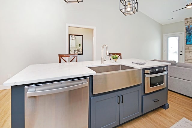 1723 Glenbridge Rd, Bloomington, IL 61704 - kitchen featuring appliances with stainless steel finishes, open floor plan, light wood finished floors, vaulted ceiling, and light stone counters