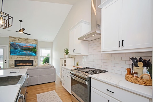 1723 Glenbridge Rd, Bloomington, IL 61704 - kitchen featuring stainless steel gas range oven, wall chimney range hood, open floor plan, lofted ceiling, and ceiling fan