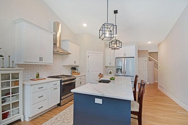 1723 Glenbridge Rd, Bloomington, IL 61704 - kitchen with appliances with stainless steel finishes, wall chimney exhaust hood, decorative backsplash, light wood-style flooring, and a breakfast bar area