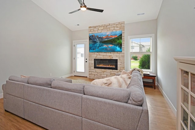 1723 Glenbridge Rd, Bloomington, IL 61704 - living room featuring a stone fireplace, a ceiling fan, wood finished floors, and vaulted ceiling