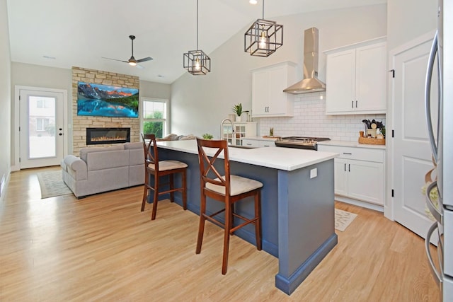 1723 Glenbridge Rd, Bloomington, IL 61704 - kitchen with wall chimney exhaust hood, ceiling fan, stainless steel fridge, backsplash, and white cabinets