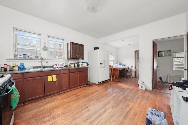 5044 W Roscoe St, Chicago, IL 60641 - kitchen with white refrigerator with ice dispenser, black gas range, light wood-style flooring, and healthy amount of natural light