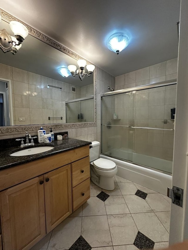 201 E Chestnut St Unit 19E, Chicago, IL 60611 - bathroom with tile walls, vanity, bath / shower combo with glass door, a chandelier, and tasteful backsplash