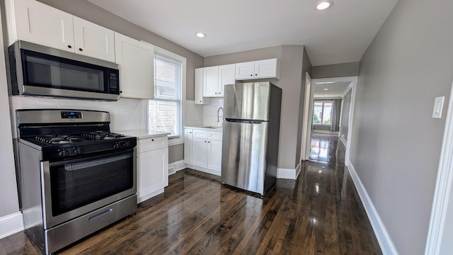 5937 W Eastwood Ave, Chicago, IL 60630 - kitchen featuring stainless steel appliances, dark wood finished floors, light countertops, white cabinets, and decorative backsplash