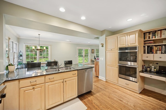 1054 Seneca Rd, Wilmette, IL 60091 - kitchen with stainless steel appliances, light brown cabinets, light wood-style floors, dark stone counters, and ornamental molding