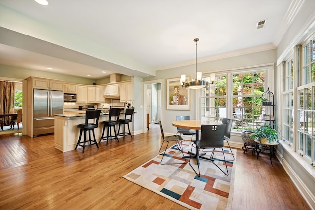 1054 Seneca Rd, Wilmette, IL 60091 - dining room featuring healthy amount of natural light, a chandelier, light wood-style flooring, ornamental molding, and recessed lighting