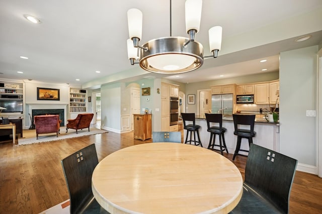 1054 Seneca Rd, Wilmette, IL 60091 - dining space featuring a fireplace, wood finished floors, recessed lighting, and built in shelves
