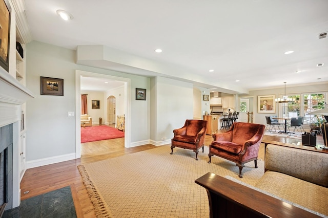 1054 Seneca Rd, Wilmette, IL 60091 - living room featuring a fireplace, arched walkways, wood finished floors, recessed lighting, and a chandelier