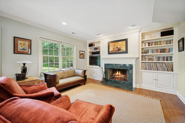 1054 Seneca Rd, Wilmette, IL 60091 - living room featuring a high end fireplace, wood finished floors, crown molding, built in shelves, and recessed lighting