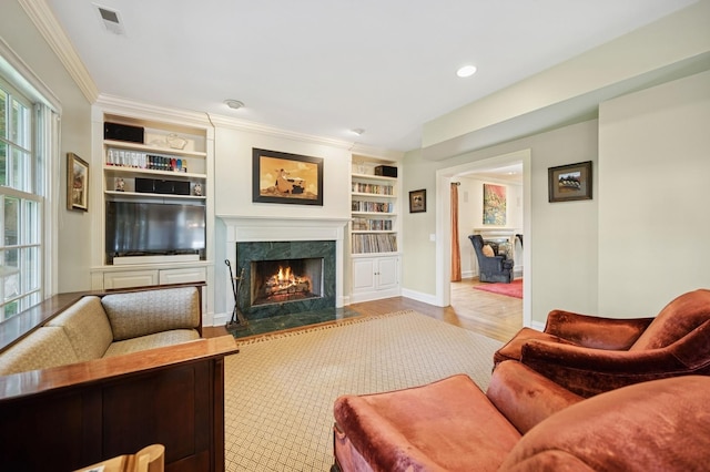 1054 Seneca Rd, Wilmette, IL 60091 - living room with a premium fireplace, built in shelves, wood finished floors, recessed lighting, and crown molding