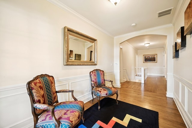 1054 Seneca Rd, Wilmette, IL 60091 - living area with arched walkways, an upstairs landing, a decorative wall, ornamental molding, and wood finished floors
