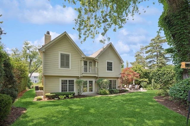 1054 Seneca Rd, Wilmette, IL 60091 - rear view of house with a balcony, a chimney, a lawn, french doors, and a patio