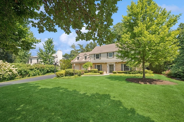 1054 Seneca Rd, Wilmette, IL 60091 - view of front facade with driveway, a front yard, and brick siding