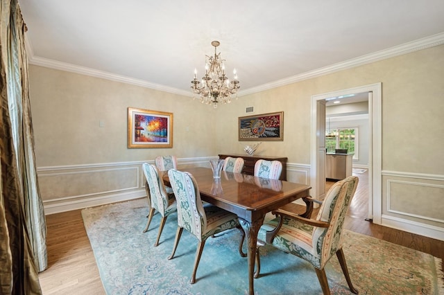 1054 Seneca Rd, Wilmette, IL 60091 - dining space featuring a chandelier, wood finished floors, ornamental molding, and wainscoting