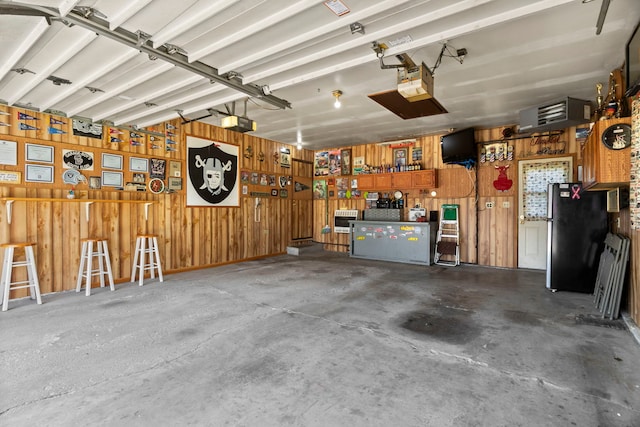 440 Charles Ct, South Elgin, IL 60177 - garage featuring freestanding refrigerator, wood walls, and a garage door opener