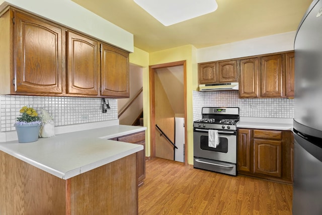 440 Charles Ct, South Elgin, IL 60177 - kitchen with appliances with stainless steel finishes, under cabinet range hood, tasteful backsplash, and light countertops