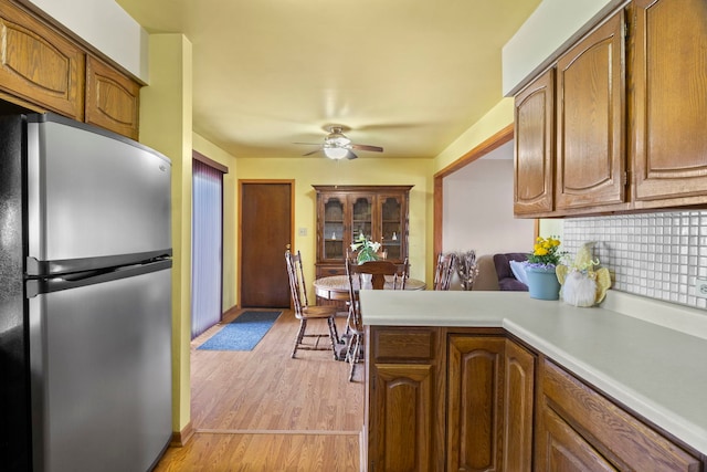 440 Charles Ct, South Elgin, IL 60177 - kitchen featuring freestanding refrigerator, brown cabinetry, ceiling fan, light countertops, and a peninsula
