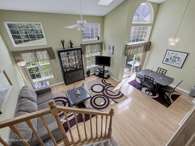 673 Kingsbridge Dr, Carol Stream, IL 60188 - living room with a towering ceiling, wood finished floors, plenty of natural light, a ceiling fan, and a skylight