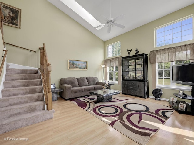 673 Kingsbridge Dr, Carol Stream, IL 60188 - living area featuring high vaulted ceiling, wood finished floors, stairway, a ceiling fan, and a skylight