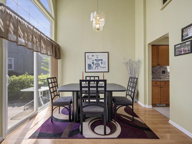 673 Kingsbridge Dr, Carol Stream, IL 60188 - dining area featuring a high ceiling, light wood-type flooring, and a chandelier