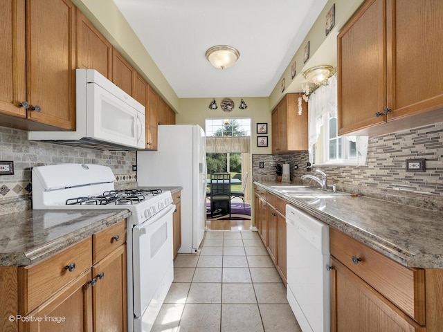 673 Kingsbridge Dr, Carol Stream, IL 60188 - kitchen with white appliances, backsplash, light tile patterned flooring, and brown cabinetry