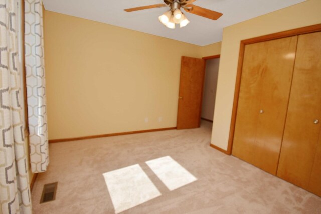 708 Wheeler Dr, Hudson, IL 61748 - unfurnished bedroom with a closet, light carpet, and a ceiling fan