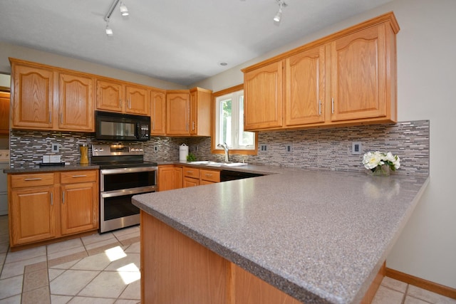 708 Wheeler Dr, Hudson, IL 61748 - kitchen with black microwave, range with two ovens, rail lighting, light tile patterned floors, and a peninsula