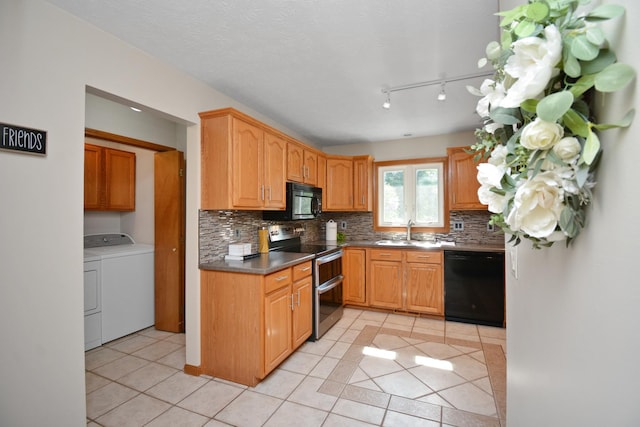708 Wheeler Dr, Hudson, IL 61748 - kitchen with black appliances, independent washer and dryer, light tile patterned flooring, backsplash, and dark countertops