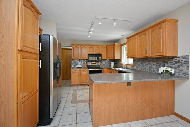 708 Wheeler Dr, Hudson, IL 61748 - kitchen with stainless steel appliances, a peninsula, light tile patterned floors, and tasteful backsplash