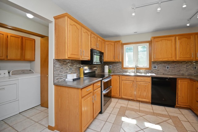 708 Wheeler Dr, Hudson, IL 61748 - kitchen featuring black appliances, washer and dryer, light tile patterned floors, backsplash, and dark countertops