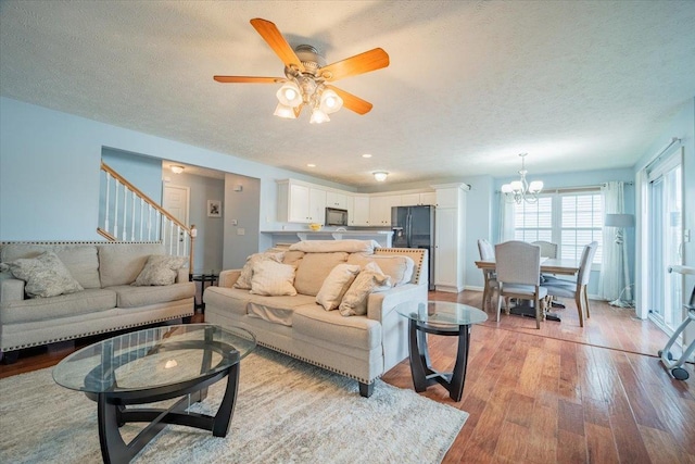 516 Wild Turkey Ln, Normal, IL 61761 - living area featuring light wood finished floors, a chandelier, stairway, a textured ceiling, and a ceiling fan