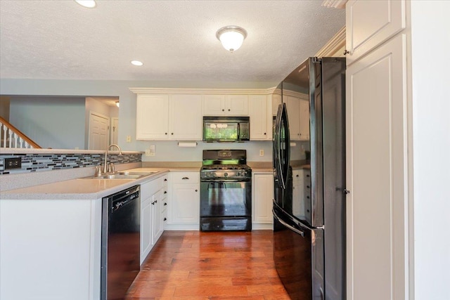 516 Wild Turkey Ln, Normal, IL 61761 - kitchen with black appliances, a peninsula, light countertops, wood finished floors, and a textured ceiling