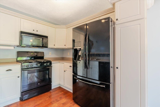 516 Wild Turkey Ln, Normal, IL 61761 - kitchen featuring black appliances, light countertops, light wood finished floors, white cabinets, and a textured ceiling