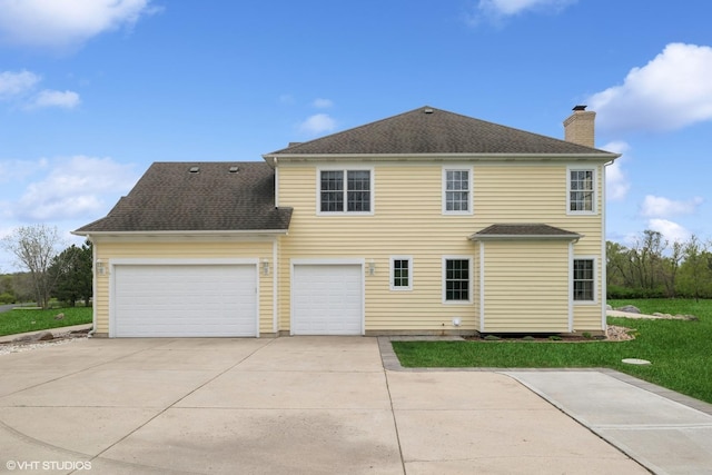 7271 Orchard Valley Dr, Bull Valley, IL 60050 - back of property with a chimney, concrete driveway, an attached garage, a lawn, and roof with shingles
