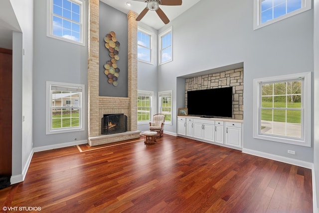7271 Orchard Valley Dr, Bull Valley, IL 60050 - living room with a brick fireplace, a towering ceiling, dark wood-type flooring, and ceiling fan