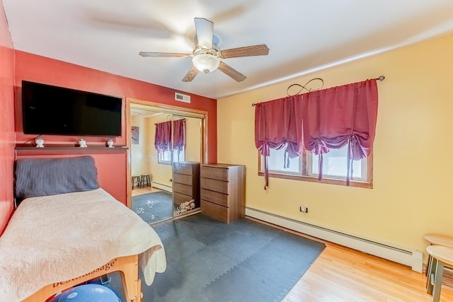 2418 S 58th Ave, Cicero, IL 60804 - bedroom with a baseboard heating unit, wood finished floors, and a ceiling fan