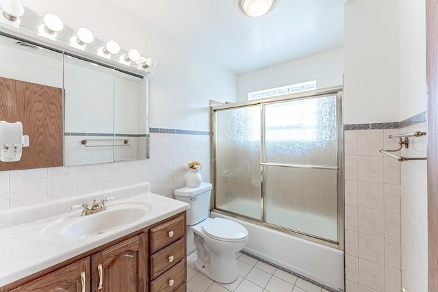 2418 S 58th Ave, Cicero, IL 60804 - bathroom featuring tile walls, vanity, tile patterned floors, bath / shower combo with glass door, and wainscoting