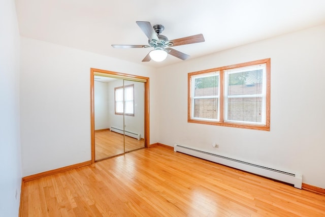 2418 S 58th Ave, Cicero, IL 60804 - unfurnished bedroom with a baseboard heating unit, light wood-style flooring, a closet, and ceiling fan